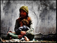 A Garwali Mother Sits in front of her cottage wall!