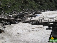 Crossing the Parvati river with a broken log bridge